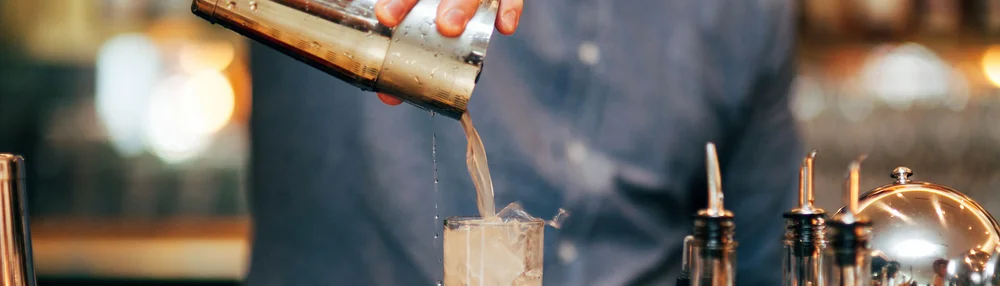 A drink being poured at the counter
